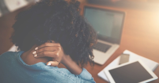 a woman working from home grabbing her neck