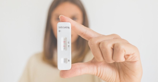woman holding a COVID-19 test